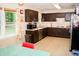 A kitchen with dark cabinets and a view of the outside through a window at 2592 King Louis Ne Rd, Conyers, GA 30012