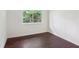 Bright bedroom with dark hardwood floors and a window looking out to lush greenery at 4096 Audubon Dr, Marietta, GA 30068