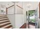 Inviting entryway with hardwood floors, stairs with wooden railing, and natural light streaming through a large front door at 4096 Audubon Dr, Marietta, GA 30068