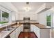 Bright kitchen featuring white cabinets, stainless steel appliances, and wood floors at 4096 Audubon Dr, Marietta, GA 30068
