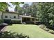 Picturesque backyard view with a well-maintained lawn, elegant home architecture, mature trees, and landscaping at 4309 Sentinel Post Nw Rd, Atlanta, GA 30327