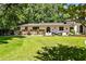Sprawling backyard showcasing lush green lawn, a stone patio, mature trees, and a charming one-story home at 4309 Sentinel Post Nw Rd, Atlanta, GA 30327