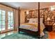 Stylish bedroom with a stone accent wall, hardwood floors, a four-poster bed, and access to an outdoor balcony at 4309 Sentinel Post Nw Rd, Atlanta, GA 30327
