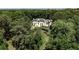 An estate home with white exterior and lush green trees and plantings surrounding it at 4309 Sentinel Post Nw Rd, Atlanta, GA 30327