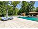 An inviting pool area with lounge chairs on the deck, a pool house, and a diving board set amidst lush trees at 4309 Sentinel Post Nw Rd, Atlanta, GA 30327
