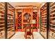 A large, wooden custom wine cellar with glass doors showcases bottles and boxes of wine with a small table in front at 4309 Sentinel Post Nw Rd, Atlanta, GA 30327