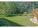Beautiful backyard featuring a well-manicured lawn, mature trees, and stone paver accents at 530 Chicapoo Dr, Marietta, GA 30066