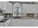 This kitchen features white cabinets, stainless steel appliances, and a gray tile backsplash at 530 Chicapoo Dr, Marietta, GA 30066