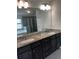 Primary bathroom with double vanity, granite countertop, tiled floor, and glass shower at 2363 Bear Mountain St, Lithonia, GA 30058