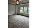 Spacious carpeted bedroom with natural light from three large windows at 2363 Bear Mountain St, Lithonia, GA 30058