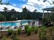 Fenced community pool area with lounge chairs, well-maintained landscaping, and nearby trees at 2363 Bear Mountain St, Lithonia, GA 30058
