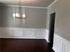 Dining room featuring wood floors, decorative wainscoting, and a modern chandelier at 2363 Bear Mountain St, Lithonia, GA 30058