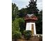 Stone and wood entrance feature surrounded by green landscaping at 2363 Bear Mountain St, Lithonia, GA 30058
