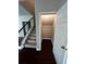 A view of the carpeted staircase with iron railing and small storage room underneath at 2363 Bear Mountain St, Lithonia, GA 30058
