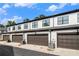 New townhome garages with dark doors and white siding under a blue sky with some clouds at 2406 Lakeshore Ln, Atlanta, GA 30316