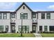 Charming townhome showcasing a painted brick facade, black framed windows, and manicured lawn at 2406 Lakeshore Ln, Atlanta, GA 30316