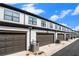 Row of townhome garages with white siding, dark trim, and brown doors under a blue sky at 2406 Lakeshore Ln, Atlanta, GA 30316