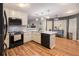 This kitchen features wood floors, stainless steel appliances, and a view into the connected living space at 4746 Mulberry Rock Rd, Dallas, GA 30157