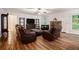 Spacious living room featuring hardwood floors, stone fireplace, and plush leather seating, perfect for relaxation at 4746 Mulberry Rock Rd, Dallas, GA 30157