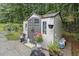 Exterior view of a backyard storage shed, enhanced by landscaping and garden decor on the property at 4746 Mulberry Rock Rd, Dallas, GA 30157