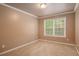 Cozy carpeted bedroom with neutral paint, window, and ceiling light at 1684 Tailmore Ln, Lawrenceville, GA 30043