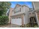 Side view of charming two-story townhome with attached two-car garage and landscaped yard at 1684 Tailmore Ln, Lawrenceville, GA 30043