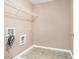 Neutral laundry room with overhead shelving and utility connections at 1684 Tailmore Ln, Lawrenceville, GA 30043