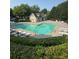 Community pool featuring a unique heart shape, ample seating, and a nearby pool house at 1684 Tailmore Ln, Lawrenceville, GA 30043