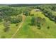 Scenic aerial view captures the sprawling landscape with a modern home nestled among mature trees and green fields at 1971 Centennial Rd, Rutledge, GA 30663