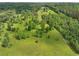 Majestic aerial view shows a peaceful property featuring acres of green land and a home enveloped by verdant trees at 1971 Centennial Rd, Rutledge, GA 30663
