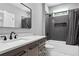 Modern bathroom featuring dark tile in shower, sleek vanity with ample storage, and updated fixtures at 1971 Centennial Rd, Rutledge, GA 30663
