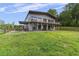 View of the home's exterior, showcasing the covered deck and outdoor seating, and the ample yard at 1971 Centennial Rd, Rutledge, GA 30663