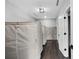 Hallway with covered storage along the wall, dark hardwood floors, and light gray walls at 1971 Centennial Rd, Rutledge, GA 30663