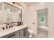 Modern bathroom with double vanity, dark fixtures, gray cabinetry, and a shower with tiled walls at 2625 Beverly Ln, Snellville, GA 30078