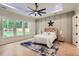 Bright primary bedroom with a decorative accent wall, tray ceilings, a ceiling fan and large windows at 2625 Beverly Ln, Snellville, GA 30078