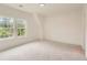Bright bedroom features neutral carpet, wall paneling, and large windows overlooking a lush landscape at 2625 Beverly Ln, Snellville, GA 30078