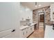 Contemporary kitchen with white cabinetry, quartz countertops, brick wall detail, and an adjacent walk-in pantry at 2625 Beverly Ln, Snellville, GA 30078