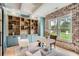 Stylish office featuring custom built-ins, brick wall accent, and abundant natural light from large windows at 2625 Beverly Ln, Snellville, GA 30078
