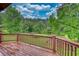 A view of a lush green lawn, mature trees, and blue sky from a wooden deck at 2905 Cammie Wages Rd, Dacula, GA 30019