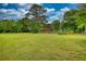 Large grassy backyard with mature trees, play structures, and plenty of open space for outdoor activities and relaxation at 2905 Cammie Wages Rd, Dacula, GA 30019