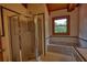 Bathroom featuring tiled walls and floor, glass enclosed shower, and tub under window at 2905 Cammie Wages Rd, Dacula, GA 30019