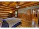 Bedroom with wood floors, log walls, dresser, and a door to a balcony at 2905 Cammie Wages Rd, Dacula, GA 30019