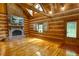Inviting living room featuring a stone fireplace and beautiful log walls for a cozy, rustic feel at 2905 Cammie Wages Rd, Dacula, GA 30019