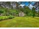 View of the property showcasing an outdoor shed on a well-maintained lawn, providing extra storage at 2905 Cammie Wages Rd, Dacula, GA 30019