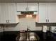 Kitchen features stainless steel sink, granite countertops, and white cabinets with modern fixtures at 6851 Roswell Rd # D33, Atlanta, GA 30328