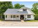 Charming white farmhouse with a covered porch and well-manicured landscaping at 999 Bailey Rd, Woodstock, GA 30188