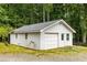 Detached garage offering ample parking and storage, surrounded by mature trees at 999 Bailey Rd, Woodstock, GA 30188