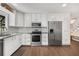 Renovated kitchen featuring stainless steel appliances, white subway tile, granite counters, and ample white cabinetry at 999 Bailey Rd, Woodstock, GA 30188