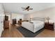 Bright main bedroom features neutral decor, a plush bed, ceiling fan, and beautiful wood flooring at 999 Bailey Rd, Woodstock, GA 30188