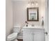 Stylish powder room boasts a white vanity, wood-framed mirror, updated fixtures, and a modern toilet providing convenient luxury at 999 Bailey Rd, Woodstock, GA 30188